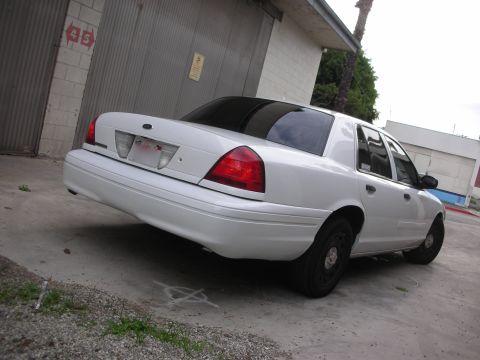 2004 Ford Crown Victoria - Rear 3/4 view of a white 2004 Ford Crown Victoria parked outdoors.