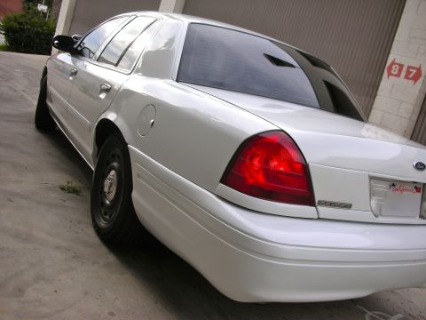 2004 Ford Crown Victoria - White Ford Crown Victoria, likely a 2003 model, seen from the rear quarter angle.