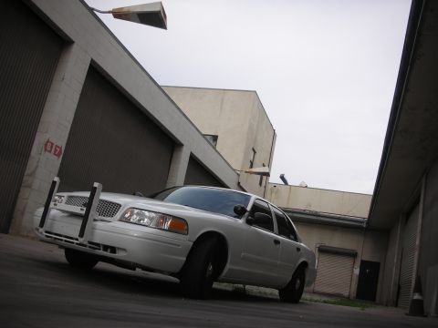 2004 Ford Crown Victoria - Front view of a white 2004 Ford Crown Victoria police car with a push bumper.