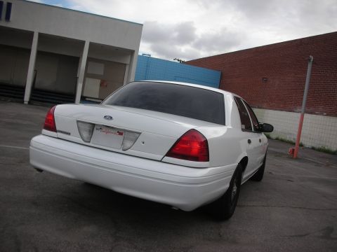 2004 Ford Crown Victoria - Rear view of a white 2004 Ford Crown Victoria parked in an urban setting.