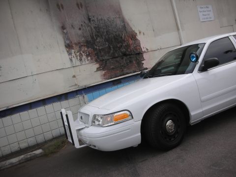 2004 Ford Crown Victoria - Front corner view of a white 2004 Ford Crown Victoria police car, equipped with a push bumper.