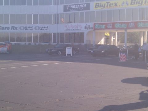 2001 Ford Crown Victoria - A scene of a parking lot with multiple vehicles and commercial buildings in the background.