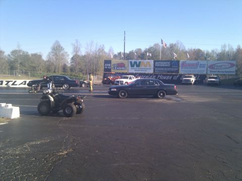 2001 Ford Crown Victoria - Drag strip scene with a 2001 Ford Crown Victoria and an ATV, under a clear sky.