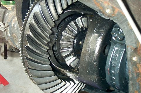 1995 Ford Bronco - Extreme close-up inside an open differential housing showing the ring gear teeth meshing with the pinion gear, with the ring-gear-mounted s…