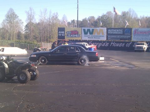 2001 Ford Crown Victoria - A black 2001 Ford Crown Victoria performs a burnout on the drag strip.