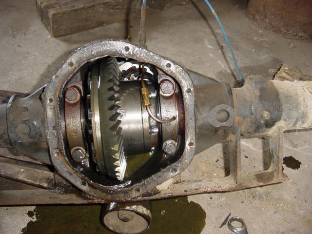 Open differential housing showing ring gear and carrier inside an axle on a shop floor