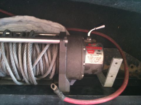 1982 Ford Bronco - A WARN XD 9000 winch is visible, attached to a metal bracket with red power cables.