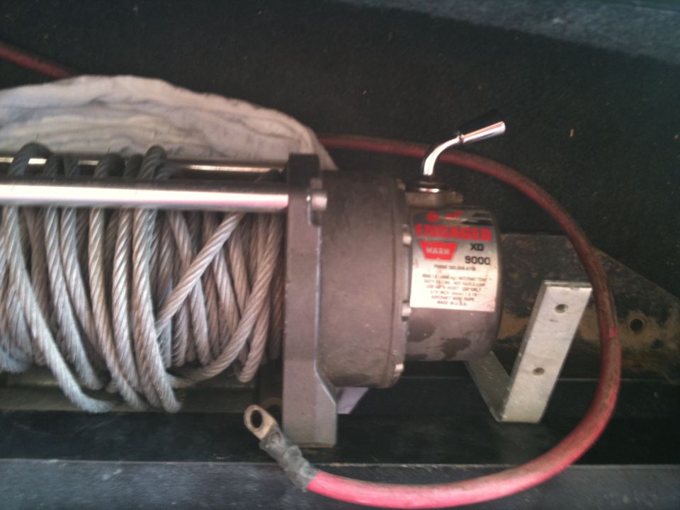 Winch with steel cable and red power cable, mounted on metal bracket