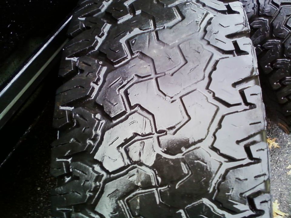 Close-up of a black tire tread with a Supermotors.net watermark