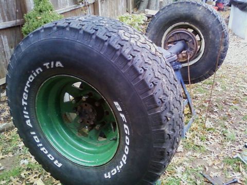 1990 Ford Bronco - A pair of BFGoodrich All-Terrain T/A tires are mounted on green rims and displayed outdoors.