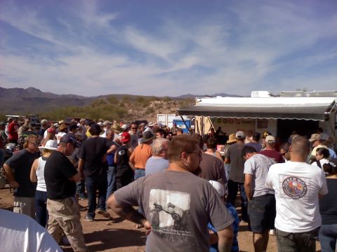 1996 Ford Bronco - A large group of people are gathered outdoors, with a vendor stand and mountains visible.