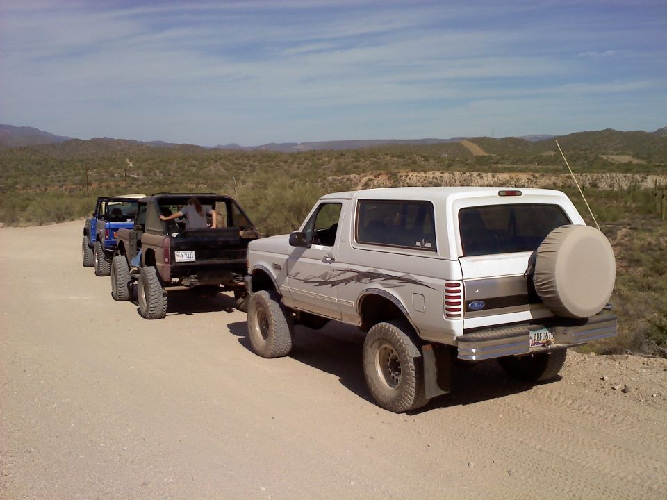 White 1996 Ford Bronco with graphics, spare tire, seen from rear