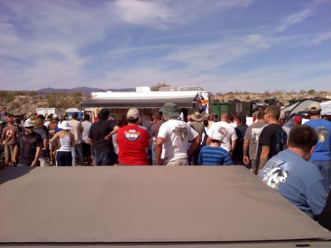 1996 Ford Bronco - A crowd of people are gathered outdoors near tents and a food truck.