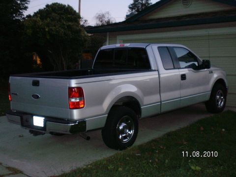 1996 Ford Bronco - Silver pickup truck parked in driveway at dusk.