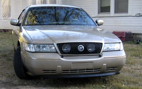 2000 Mercury Grand Marquis - Front view of a gold 2000 Mercury Grand Marquis parked outdoors.