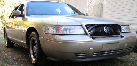 2000 Mercury Grand Marquis - Gold 2000 Mercury Grand Marquis sedan parked outdoors, front view.