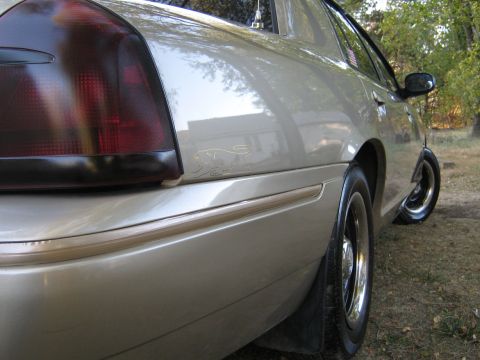 2000 Mercury Grand Marquis - Rear view of a silver sedan, showing its quarter panel and tinted taillight.