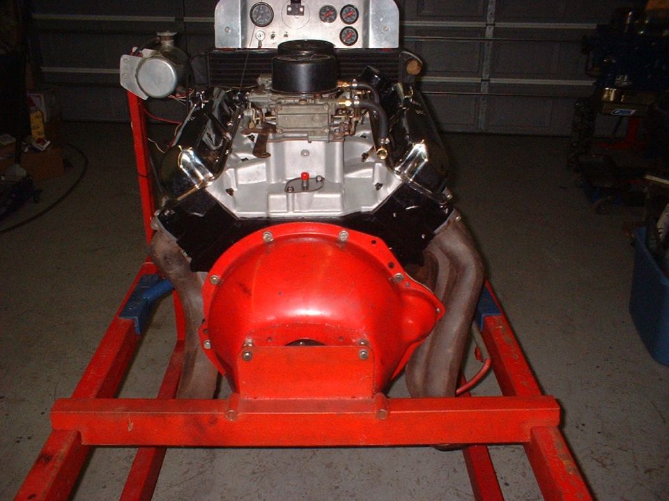 V8 engine on an orange stand with a red transmission bell housing