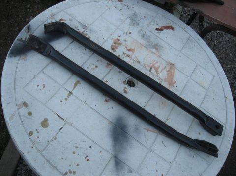 1981 Ford Bronco - Two black metal bars are placed on a white plastic table, with a watermark at the bottom right.