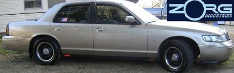 2000 Mercury Grand Marquis - Side profile of a 2000 Mercury Grand Marquis sedan with tan paint and black wheels.