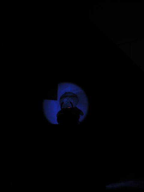 1996 Ford Bronco - A toy figure is dimly lit by a blue spotlight in this dark image.