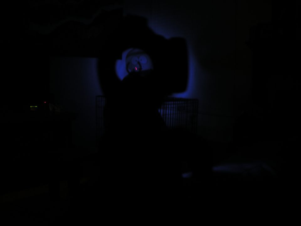 Dark interior with blue light illuminating a circular object and a ribbed surface