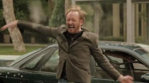 1993 Ford Taurus - A man reacts dramatically next to a car that appears to have been shot at.