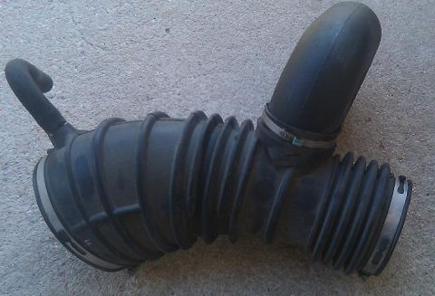 2000 Mercury Grand Marquis - This is a black rubber air intake hose, likely a replacement part for a vehicle. It features ribbed bellows for flexibility and metal clamp…