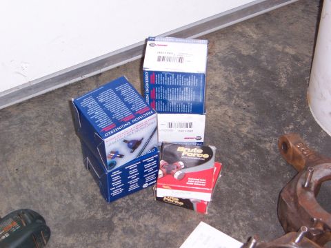 1992 Ford Bronco - Boxes of automotive parts, including "Brute Force" U-joints, are stacked on a concrete floor.