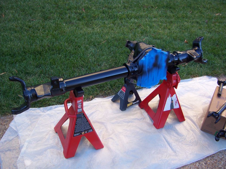 Ford Bronco front axle assembly on red jack stands, painted black with blue masking tape on differential