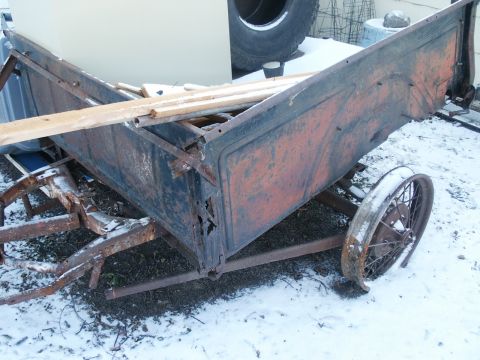 1990 Ford Bronco - A rusted trailer bed, likely from an old truck or car, sits in the snow with wooden planks inside.