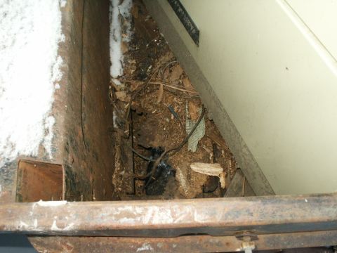 1990 Ford Bronco - Debris and snow are visible in the undercarriage of a vehicle, suggesting a scene of disrepair or storage.