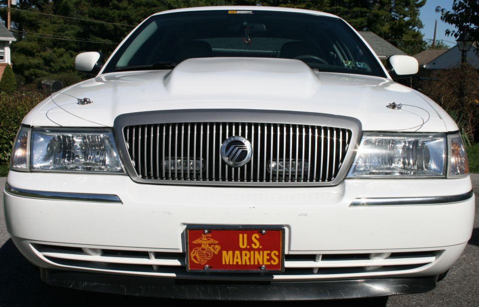 White 2005 Mercury Grand Marquis front view with custom hood scoop and US Marines license plate