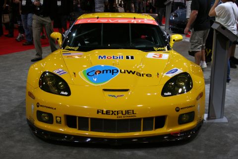 1998 Ford Crown Victoria - Front view of a yellow Chevrolet Corvette race car with Compuware and Mobil 1 sponsor livery and a number 3 at an indoor display.