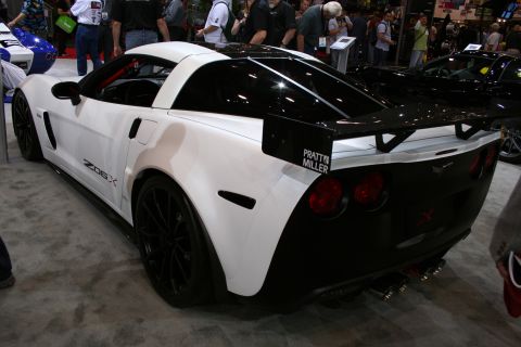 1998 Ford Crown Victoria - Rear three-quarter view of a white Corvette Z06X coupe with a large rear wing and Pratt Miller graphics at an indoor show.