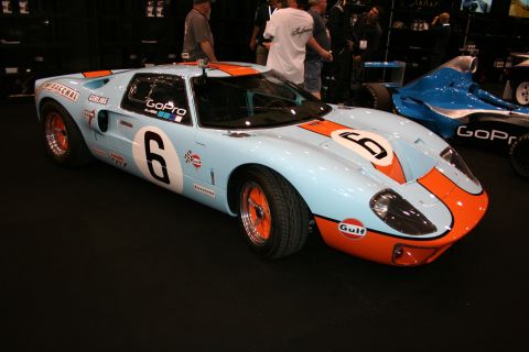 1998 Ford Crown Victoria - light-blue and orange Gulf-liveried endurance race coupe wearing number 6 is displayed front-three-quarter on a dark show floor.