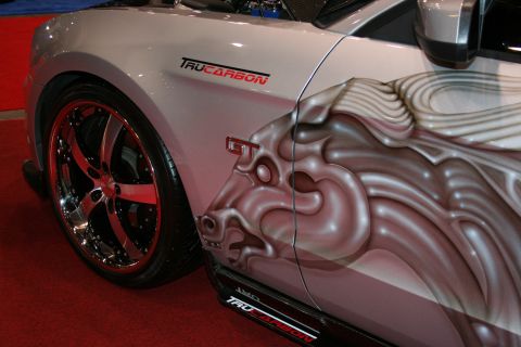 1998 Ford Crown Victoria - close-up of a silver coupe's rear quarter shows TruCarbon and GT badges, an airbrushed face mural and a chrome multi-spoke wheel with red c…