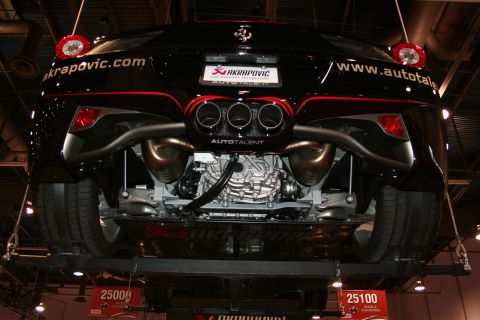 1998 Ford Crown Victoria - Rear underbody view of a black Ferrari raised on a display lift, exposing a triple-tip Akrapovic exhaust and the rear engine and suspension.