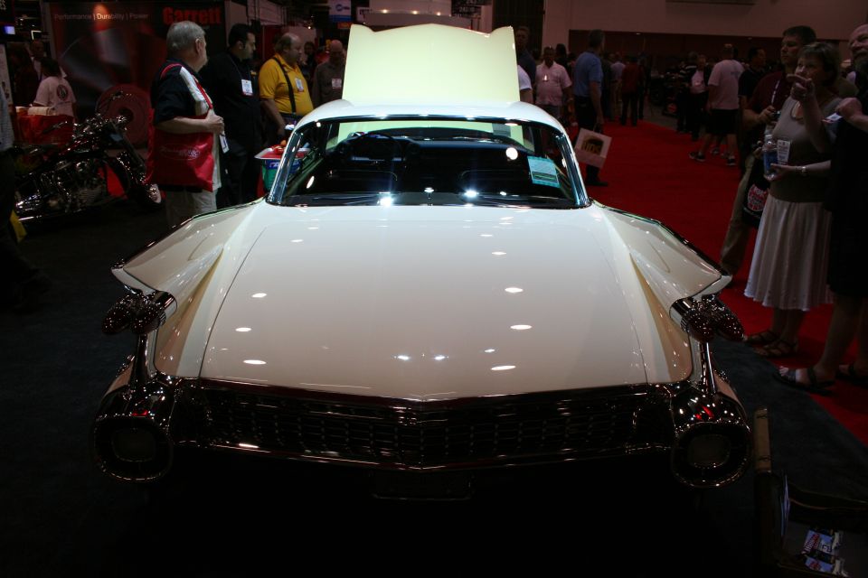 Front view of cream 1950s Cadillac with chrome bumper and open hood