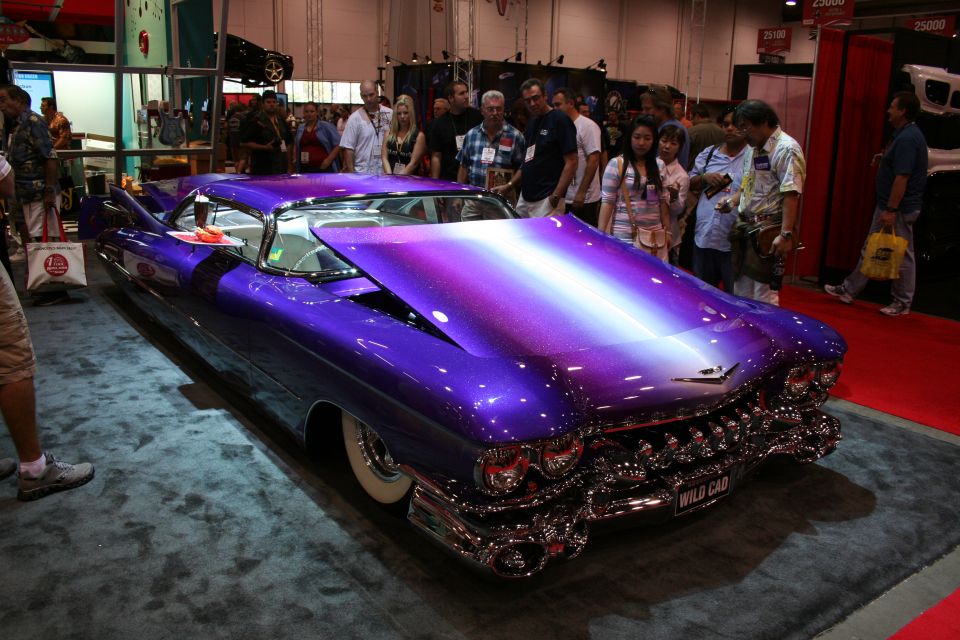 Purple metalflake custom Cadillac lowrider with whitewall tires at show