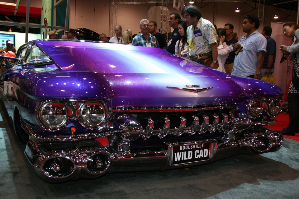 Front of purple custom Cadillac with chrome grille and WILD CAD plate