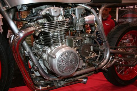 1998 Ford Crown Victoria - Close-up of a vintage Honda inline-four motorcycle engine with chrome exhaust headers and carburetors on a custom build.