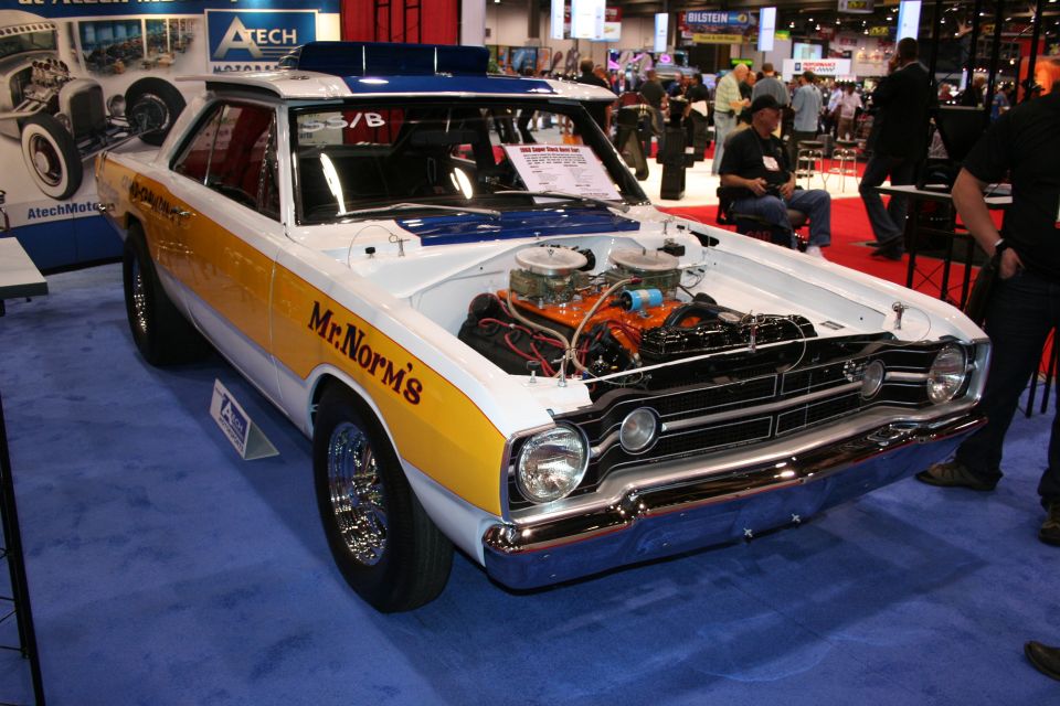 Yellow and white Mr. Norm's Dodge Dart drag car with exposed V8 engine