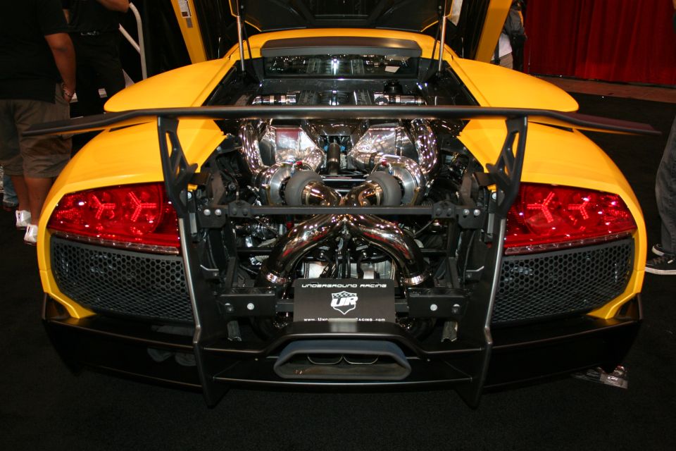 Rear view of a yellow supercar with exposed twin-turbo engine and roll cage
