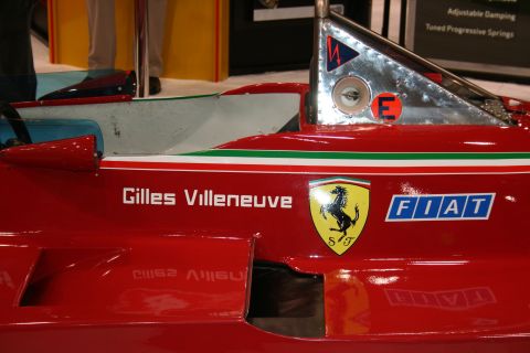 1998 Ford Crown Victoria - Side detail of a red Ferrari F1 car bearing the 'Gilles Villeneuve' name, the prancing-horse shield and a FIAT logo.