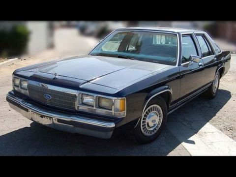 1991 Ford Crown Victoria - This Ford sedan features a chrome grille and distinct body lines.