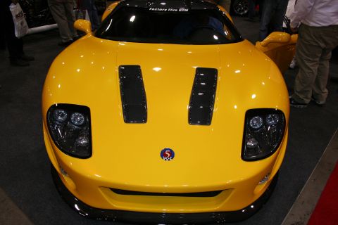 1998 Ford Crown Victoria - Head-on view of a yellow Factory Five GTM-style mid-engine sports car showing twin hood vents and a number-5 badge.
