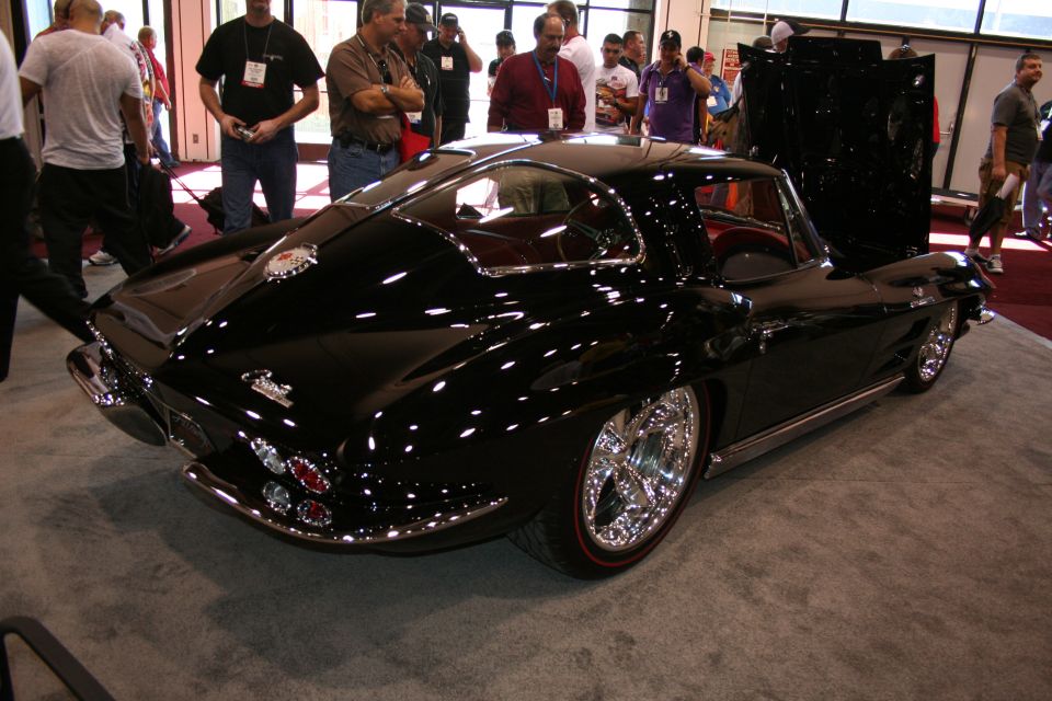 Black split-window Corvette coupe rear three-quarter at indoor car show