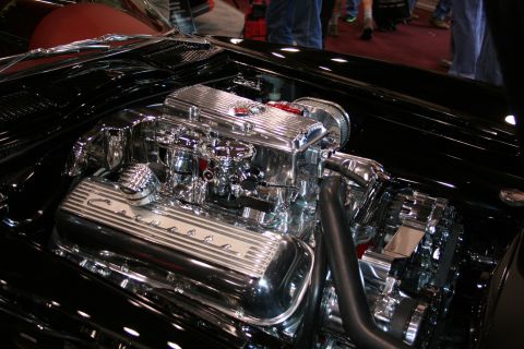 1998 Ford Crown Victoria - heavily chromed Chevrolet V8 engine bay with finned Corvette-script valve covers and polished intake under an open hood.