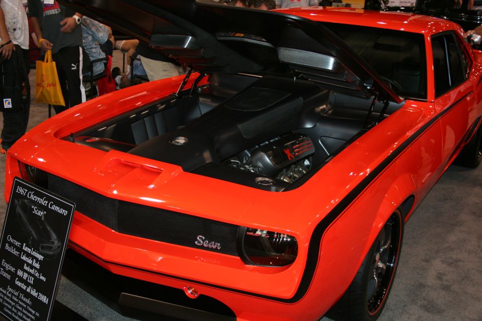 Orange 1967 Chevrolet Camaro with open hood at car show